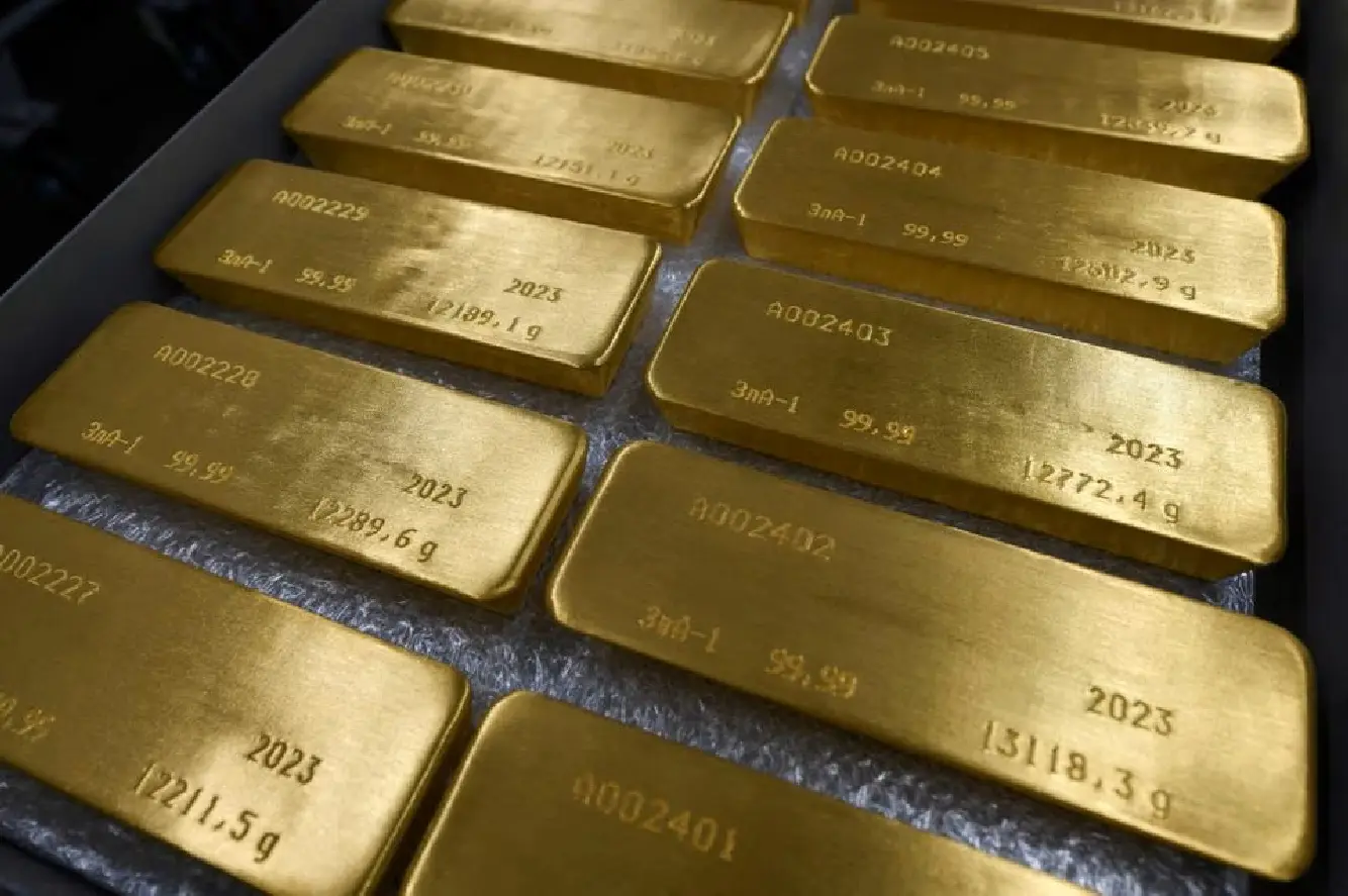 Gold off one-year highs as dollar firms ahead of US payrolls data